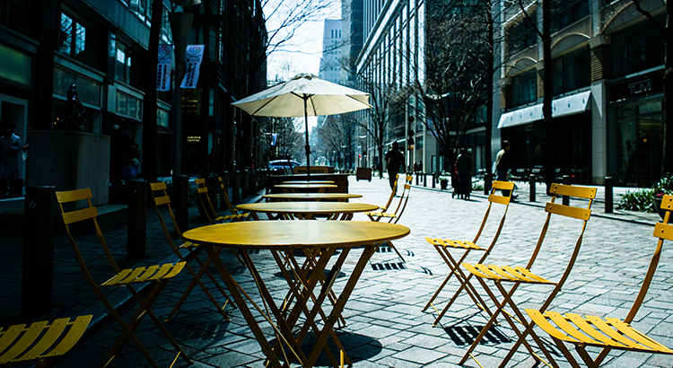 Empty Chairs And Tables At Cafe In City