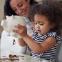 Mother and child getting money from a piggy bank